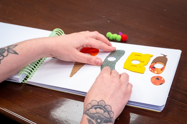 Unas manos tacando un libro en relieve