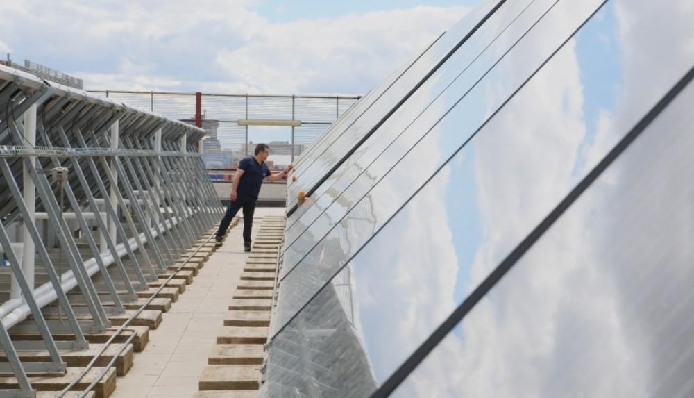Un hombre comprobando paneles solares en una sede del Grupo Social ONCE